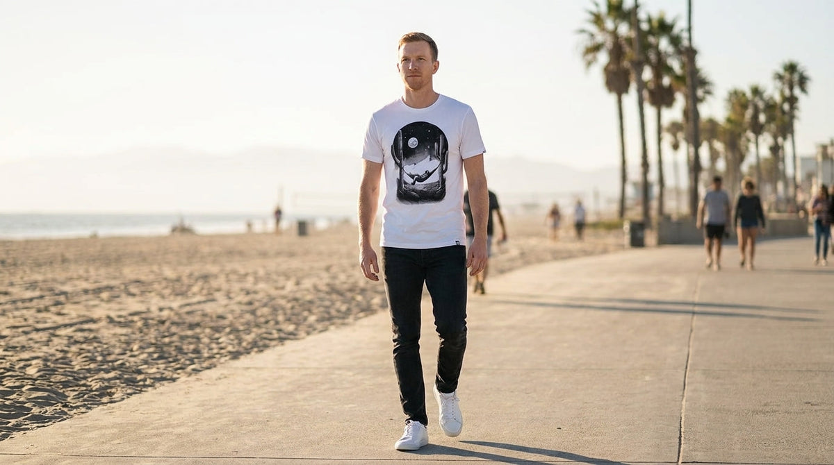 Man wearing a white INTO THE AM graphic t-shirt outdoors, best graphic tees for summer: 2026