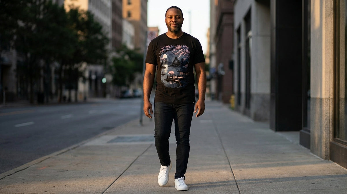 Man wearing a white INTO THE AM graphic t-shirt outdoors, best graphic tees without logos: 2026